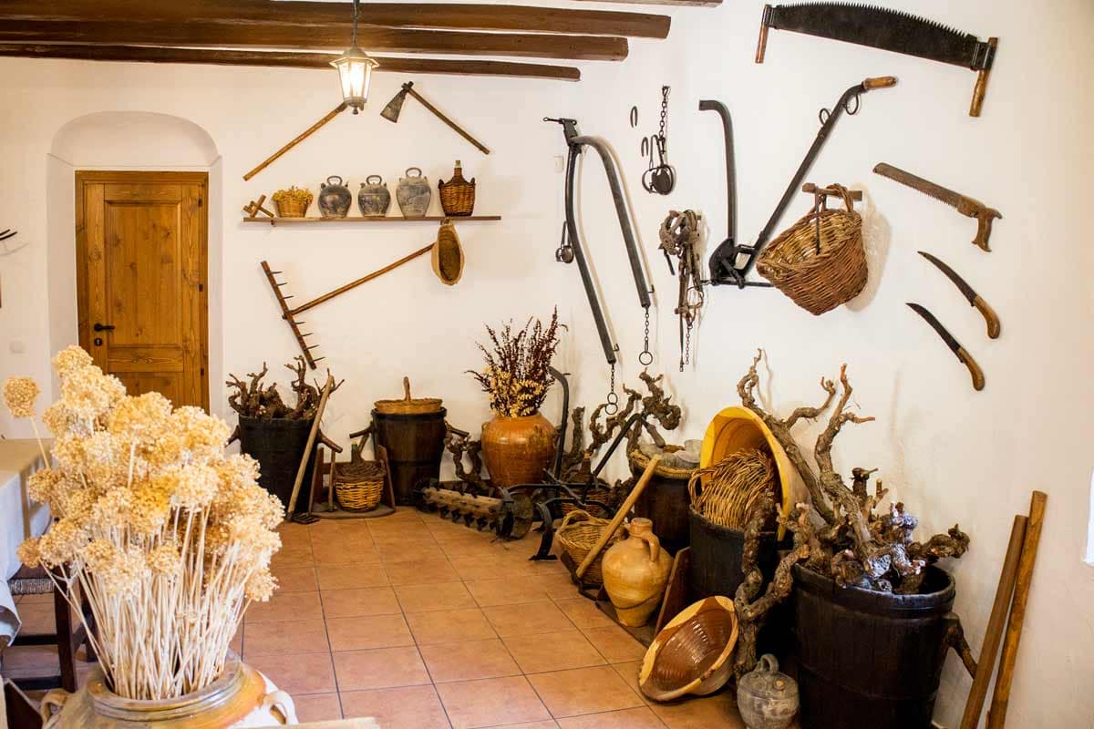 Entrada amb la paret decorada amb estris antics.